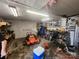 Garage featuring unfinished ceiling, riding lawn mower, workbench, and shelving at 316 Reese St, Gastonia, NC 28056