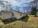 A classic home with white siding, mature trees, and shrubs adding character and privacy to the backyard at 316 Reese St, Gastonia, NC 28056