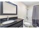 Modern bathroom with a dark vanity, matching framed mirror, and a shower-tub combo at 3334 Cloninger Rd, Dallas, NC 28034