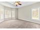 Spacious bedroom with neutral carpet, a ceiling fan, and a wall of windows for plenty of natural light at 3334 Cloninger Rd, Dallas, NC 28034