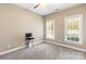 This cozy bedroom features neutral carpet, a ceiling fan, and two windows for plenty of natural light at 3334 Cloninger Rd, Dallas, NC 28034