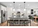 Bright kitchen features a large center island with seating, stainless steel appliances, modern pendant lights, and stylish backsplash at 5231 Hatcher Creek Rd # 44, Charlotte, NC 28215