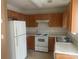 Kitchen featuring wood cabinets, white appliances, and laminate countertops at 5650 Kimmerly Woods Dr, Charlotte, NC 28215