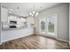 A well-lit dining area featuring modern lighting, wood-look floors, and glass doors to the outside at 10036 Brittondale Ln, Charlotte, NC 28215