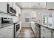 A well-equipped kitchen with stainless steel appliances, granite countertops, and white cabinetry at 10036 Brittondale Ln, Charlotte, NC 28215