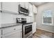 Bright kitchen features white cabinets, stainless steel appliances, and granite countertops at 10036 Brittondale Ln, Charlotte, NC 28215