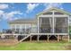 A full view of the home's back exterior, including a screened porch, fire pit, and deck at 10421 Superb Ln, Charlotte, NC 28215