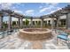 Community fire pit with an overhead pergola, stone pavers, and plenty of seating at 10421 Superb Ln, Charlotte, NC 28215