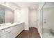 Bright main bathroom with a glass shower, double sinks, wood floors, and white cabinets at 10421 Superb Ln, Charlotte, NC 28215