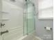 Bathroom featuring a shower with glass door, updated fixtures and ceramic tile at 107 Wedgewood Ne Cir, Concord, NC 28025