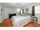 Bedroom with hardwood floors, a comfortable bed, and warm natural light filtering through the windows at 107 Wedgewood Ne Cir, Concord, NC 28025