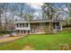 Charming home featuring a well-maintained lawn, brick facade, attached garage, and a screened-in porch at 107 Wedgewood Ne Cir, Concord, NC 28025