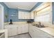 Traditional kitchen with white cabinets, blue walls, and a stainless steel sink with a window view at 107 Wedgewood Ne Cir, Concord, NC 28025