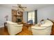 Cozy living room featuring hardwood floors, a brick fireplace, and comfortable seating arrangement at 107 Wedgewood Ne Cir, Concord, NC 28025