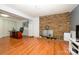 Spacious living area featuring a brick fireplace, hardwood floors, and ample space for a home office or gym at 107 Wedgewood Ne Cir, Concord, NC 28025