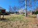 Large backyard featuring an in-ground pool, blooming trees, lush grass, and a fenced perimeter at 1301 Huckleberry Dr, Lincolnton, NC 28092