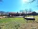 Expansive backyard features a pergola, lush lawn, brick home, and an in-ground pool with a stone waterfall feature at 1301 Huckleberry Dr, Lincolnton, NC 28092