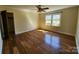Bright bedroom with hardwood floors, a ceiling fan, and large windows overlooking the landscaped yard at 1301 Huckleberry Dr, Lincolnton, NC 28092