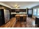 Open kitchen features stainless steel appliances, a center island with seating, and dark cabinets at 1301 Huckleberry Dr, Lincolnton, NC 28092