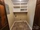 Well-lit laundry room featuring tile floors, built-in shelving, and convenient washer/dryer hookups at 1301 Huckleberry Dr, Lincolnton, NC 28092