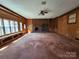 Spacious living room boasting wood paneling, a brick fireplace, and built-in shelving at 1301 Huckleberry Dr, Lincolnton, NC 28092