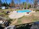 Backyard pool area with in-ground pool, concrete deck, stone waterfall feature, and outdoor seating areas at 1301 Huckleberry Dr, Lincolnton, NC 28092