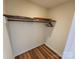 Functional walk-in closet with shelving, hanging rod, and wood-look flooring at 1301 Huckleberry Dr, Lincolnton, NC 28092