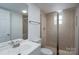 Clean bathroom with large mirror, updated lighting, tiled walk-in shower with glass door at 1413 Caldwell St, Gastonia, NC 28052