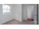 This small bedroom features a window, neutral carpet, and white trim, with an interior white door at 1413 Caldwell St, Gastonia, NC 28052