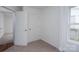 Cozy bedroom with a window, neutral carpet, and white trim, featuring an interior white door at 1413 Caldwell St, Gastonia, NC 28052