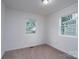 This bedroom features two windows for ample natural light, neutral carpet, and white trim at 1413 Caldwell St, Gastonia, NC 28052