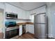 Bright kitchen featuring stainless steel appliances, including a range, microwave, dishwasher, and refrigerator at 1413 Caldwell St, Gastonia, NC 28052