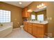 Bright bathroom featuring double sinks, a large vanity, tile flooring and garden tub at 161 Seven Springs Loop # 11, Statesville, NC 28625