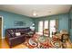 Comfortable living room with hardwood floors, ceiling fan, leather sofa, and access to the backyard at 161 Seven Springs Loop # 11, Statesville, NC 28625