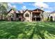 Expansive backyard featuring a brick home with a stone chimney and covered porch at 1614 Shimron Ln, Waxhaw, NC 28173