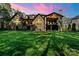 Expansive backyard featuring a brick home, covered patio, and lush green lawn at 1614 Shimron Ln, Waxhaw, NC 28173