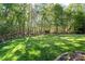 Level, grassy backyard featuring mature shade trees and decorative border at 1614 Shimron Ln, Waxhaw, NC 28173