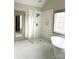 Bright bathroom with glass enclosed shower, soaking tub, and designer black and white tile flooring at 1614 Shimron Ln, Waxhaw, NC 28173