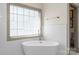 Modern bathroom with stand alone tub, window, and tile walls at 1614 Shimron Ln, Waxhaw, NC 28173