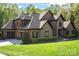 Elegant brick and stone home with a lush green lawn and mature landscaping at 1614 Shimron Ln, Waxhaw, NC 28173