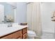 Bathroom featuring a light wood vanity, shower with modern patterned curtain, and neutral tones at 1809 Mill Creek Sw Ln, Concord, NC 28025