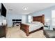 Bedroom with wooden bed frame, side tables, and a mounted television at 1809 Mill Creek Sw Ln, Concord, NC 28025