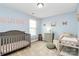 Baby Bedroom with light blue walls, featuring a crib, changing station, and decor, creating a calm environment at 1809 Mill Creek Sw Ln, Concord, NC 28025