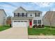 Charming two-story home featuring a red front door, attached two-car garage and well-maintained lawn at 1809 Mill Creek Sw Ln, Concord, NC 28025