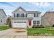 Charming two-story home with gray siding, black shutters, red front door, and well-manicured lawn at 1809 Mill Creek Sw Ln, Concord, NC 28025