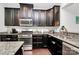Well-equipped kitchen boasts granite countertops, stainless steel appliances, and dark wood cabinetry at 1809 Mill Creek Sw Ln, Concord, NC 28025
