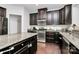 Modern kitchen with granite countertops, stainless steel appliances, dark wood cabinets, and hardwood floors at 1809 Mill Creek Sw Ln, Concord, NC 28025