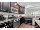 Features a stainless steel range, granite countertops, and ample dark wood cabinetry at 1809 Mill Creek Sw Ln, Concord, NC 28025