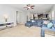 Cozy living room featuring blue sectional sofa, ceiling fan, and open access to the modern kitchen at 1809 Mill Creek Sw Ln, Concord, NC 28025