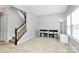 Open-concept living room with staircase, lots of natural light, and neutral walls and flooring at 1809 Mill Creek Sw Ln, Concord, NC 28025
